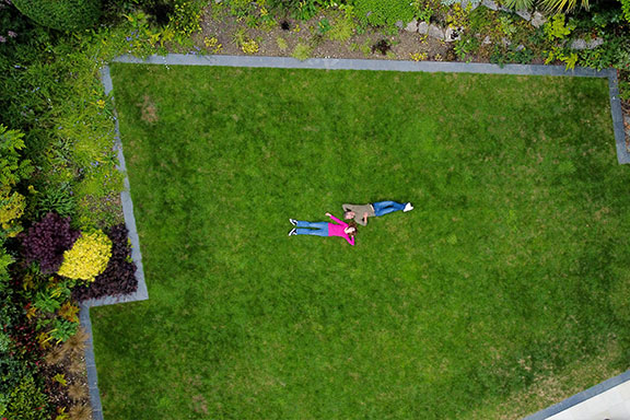 Birdseye view of large lawn with 2 customers laying on the grass