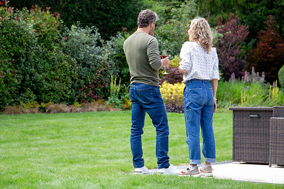 2 customers standing in their garden with their backs to the camera