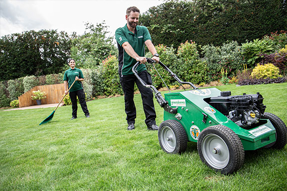 Greensleeves lawn expert using an aerator machine on a lawn
