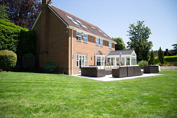 house with patio and large green lawn