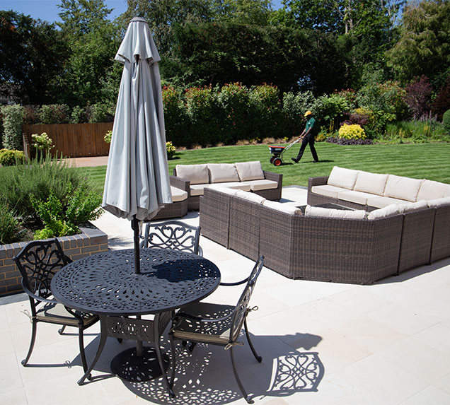 Garden patio seating with a Greensleeves garden specialist aerating the lawn
