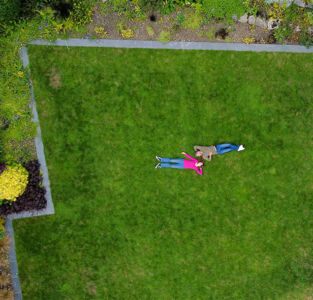 birds eye view of couple lying on large green lawn