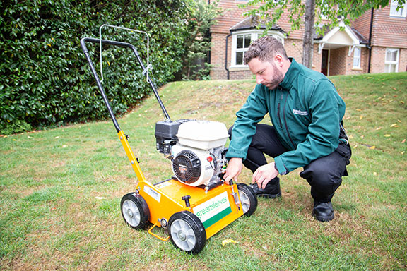 Greensleeves lawn expert setting up a scarifying machine on a lawn