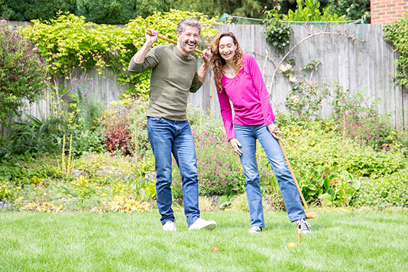 couple playing croquet on their lawn