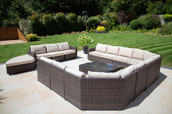 garden furniture on a patio next to a lawn