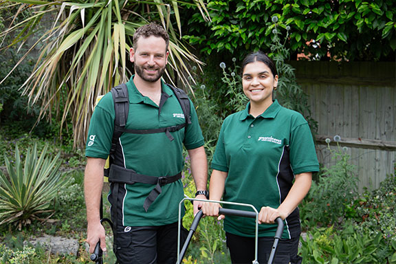 A man and woman from Greensleeves posing during a garden renovation project