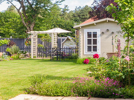 well maintained garden lawn with summerhouse behind