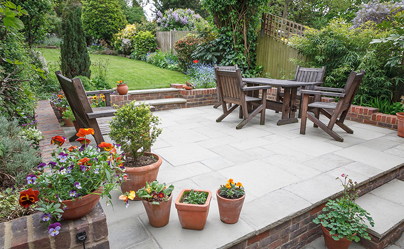 clean and tidy patio area with outdoor furniture and flower pots