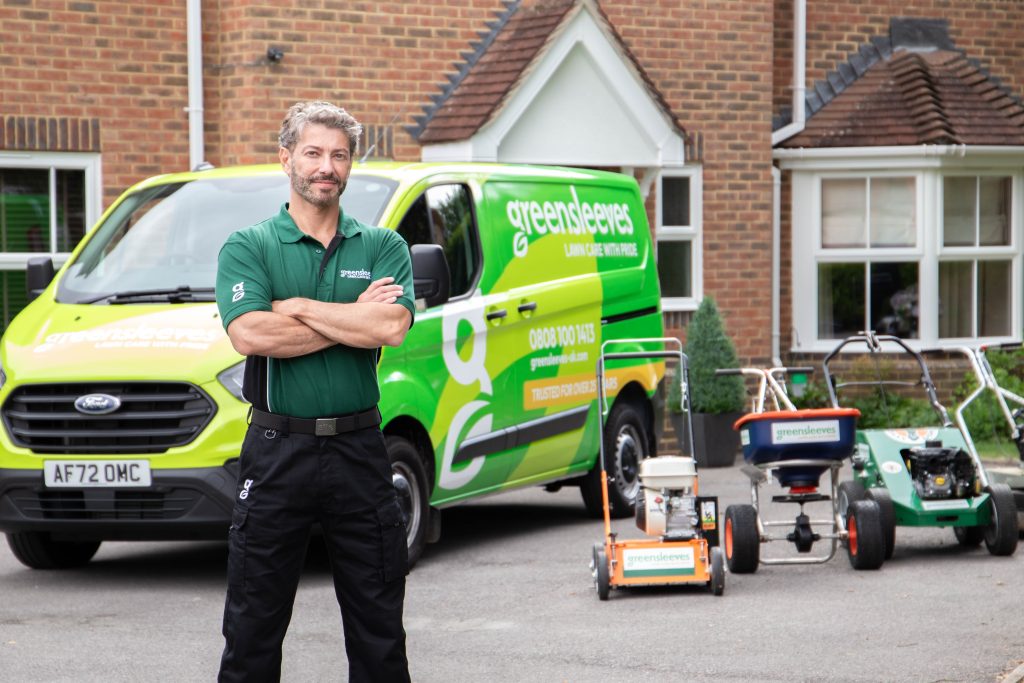 Greensleeves lawn expert stood in front of branded van and equipment